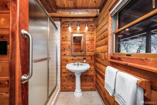 bathroom featuring tile patterned flooring, wooden ceiling, wooden walls, and a shower with shower door