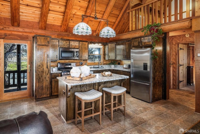 kitchen with light stone counters, a center island, hanging light fixtures, wooden ceiling, and appliances with stainless steel finishes