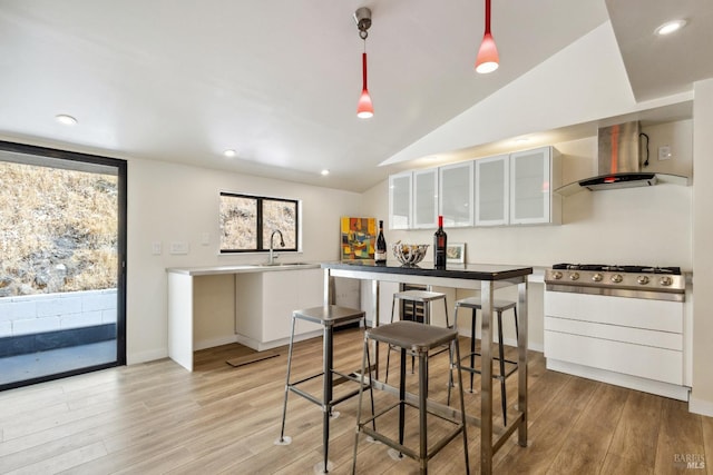 3062 Soda Canyon Rd, Napa, CA 94558 - kitchen with wall chimney range hood, white cabinetry, light wood-style flooring, vaulted ceiling, and recessed lighting
