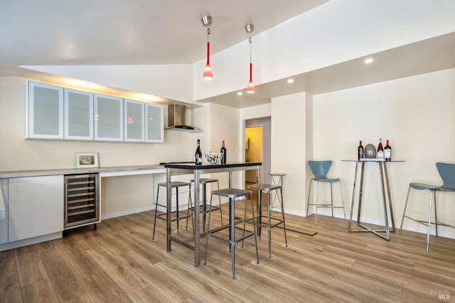 3062 Soda Canyon Rd, Napa, CA 94558 - bar area featuring beverage cooler, light wood-type flooring, wall chimney range hood, vaulted ceiling, and hanging light fixtures