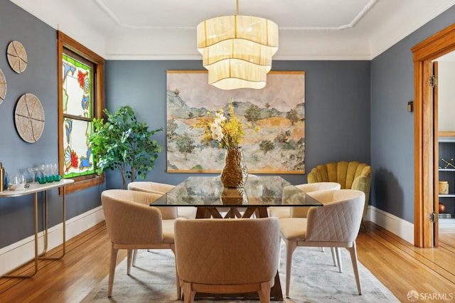 dining area with baseboards and wood finished floors