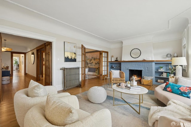 living area with a fireplace, wood finished floors, and baseboards