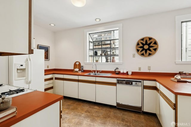 kitchen with recessed lighting, white appliances, white cabinetry, and a sink