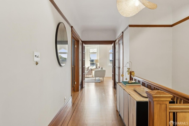 corridor with light wood-style floors and baseboards