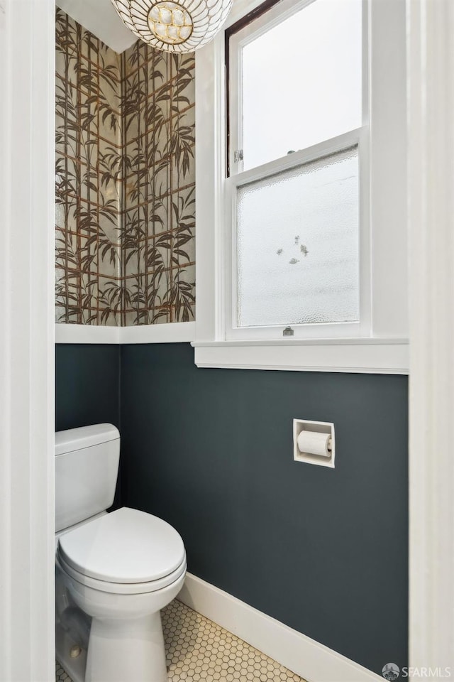 bathroom featuring toilet and baseboards