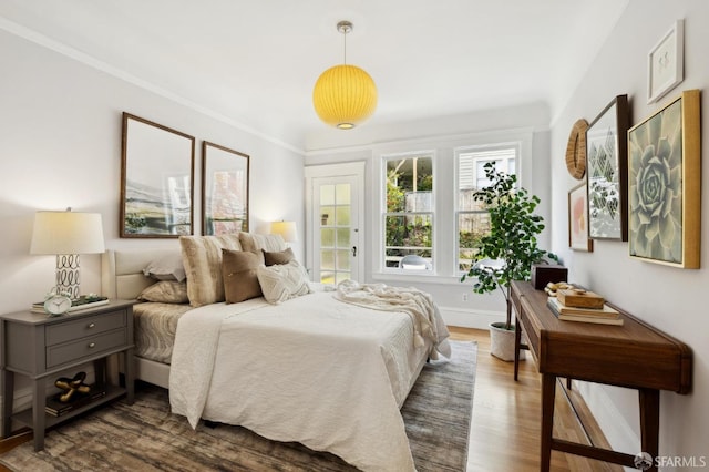 bedroom with dark wood-style floors, baseboards, and ornamental molding