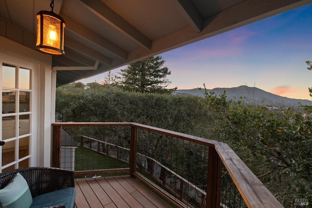 deck at dusk featuring a mountain view