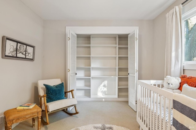 bedroom featuring a nursery area and carpet flooring