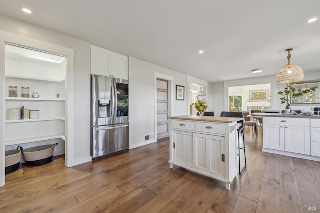 kitchen with white cabinetry, hanging light fixtures, dark hardwood / wood-style floors, a kitchen island, and stainless steel fridge with ice dispenser