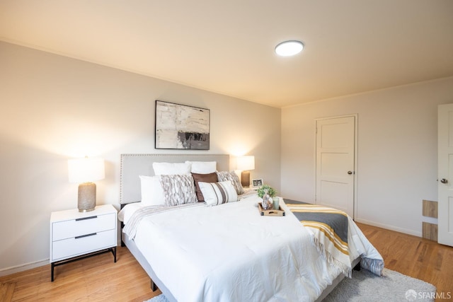 bedroom with light wood-type flooring and baseboards