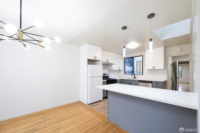 kitchen with gas stove, a sink, freestanding refrigerator, dishwasher, and a chandelier