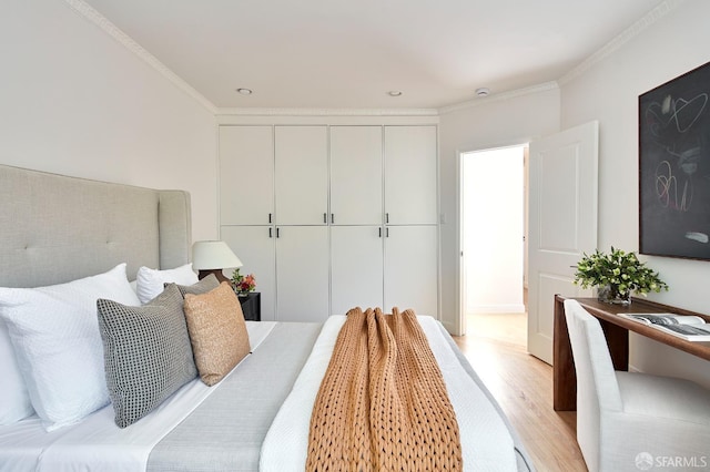 bedroom with light wood-style flooring and crown molding