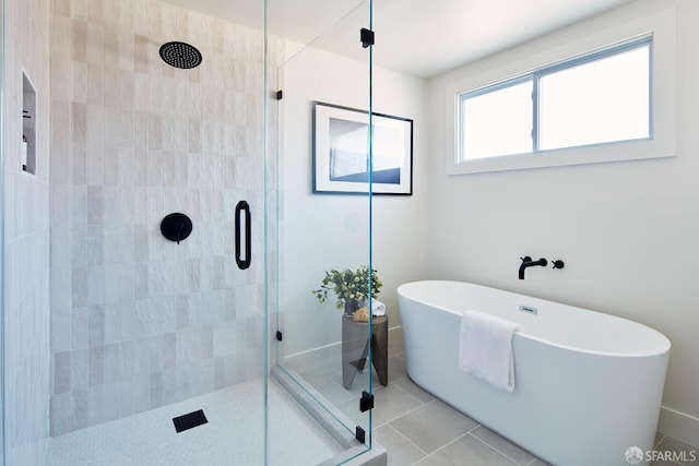 bathroom with a stall shower, a freestanding bath, and tile patterned floors