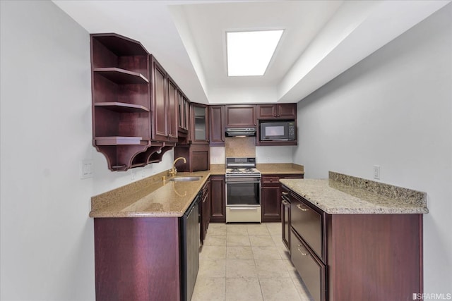 kitchen featuring gas stove, a tray ceiling, a sink, under cabinet range hood, and black microwave