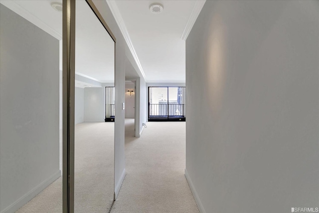 hallway featuring baseboards, carpet floors, and ornamental molding