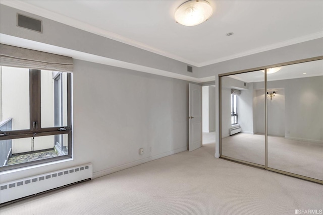 unfurnished bedroom with visible vents, light carpet, baseboard heating, and ornamental molding