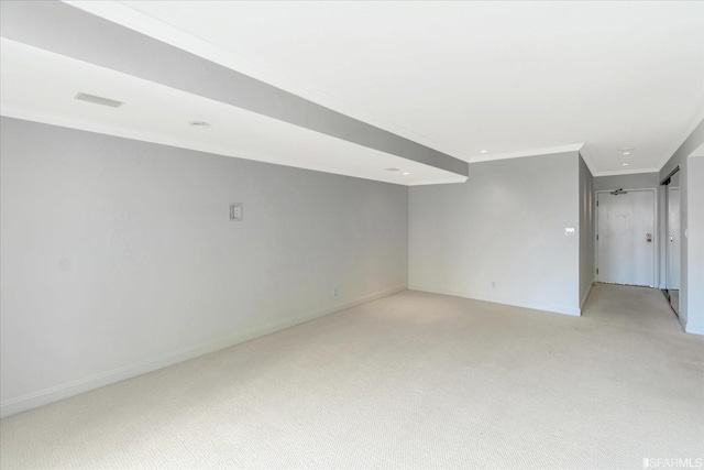 empty room featuring light colored carpet, crown molding, and baseboards