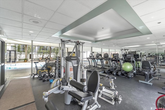 exercise room with a wall of windows and a paneled ceiling