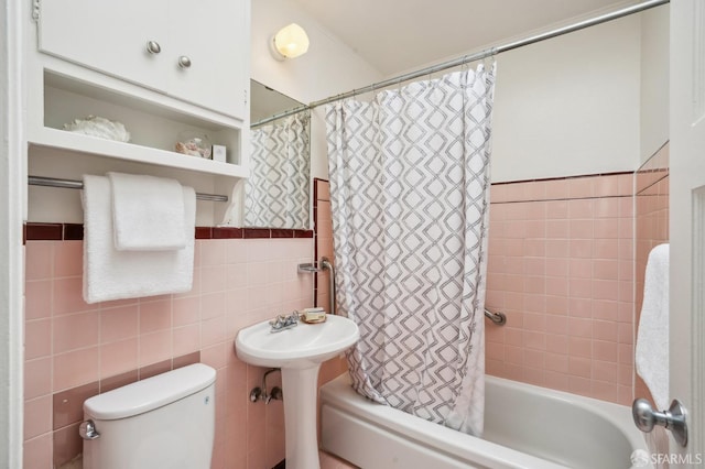 bathroom featuring toilet, tile walls, and shower / bath combo