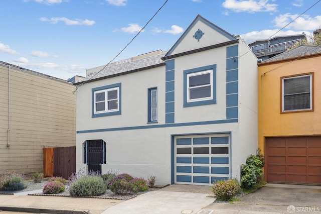 view of front facade featuring fence, an attached garage, concrete driveway, and stucco siding
