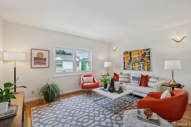 living area with baseboards and wood finished floors