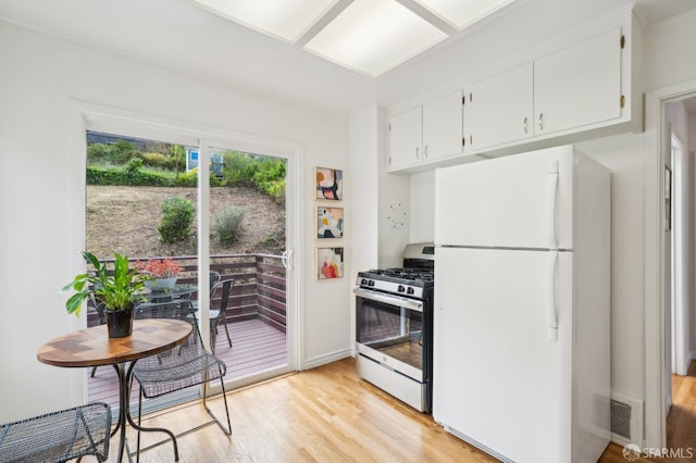 kitchen featuring light wood-style floors, freestanding refrigerator, stainless steel gas stove, and visible vents