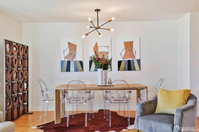 dining room with wood-type flooring and an inviting chandelier