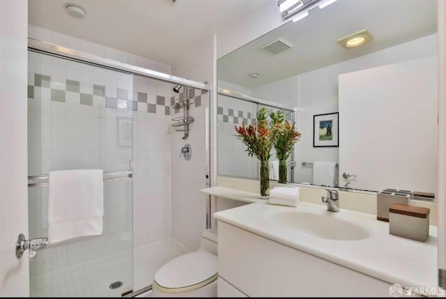 bathroom featuring vanity, toilet, and walk in shower