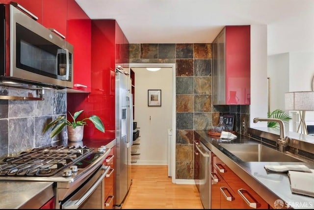 kitchen with decorative backsplash, sink, stainless steel appliances, and light hardwood / wood-style floors