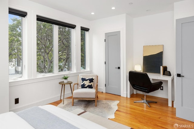 bedroom with multiple windows and hardwood / wood-style floors