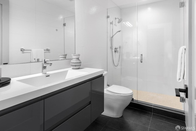 bathroom featuring tile patterned floors, vanity, an enclosed shower, and toilet