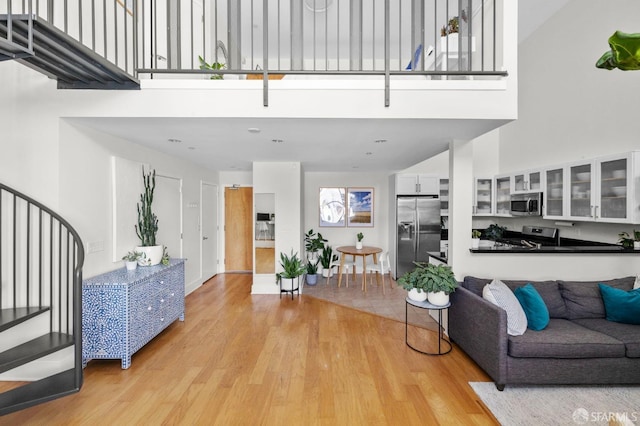 living room with a high ceiling and light wood-type flooring