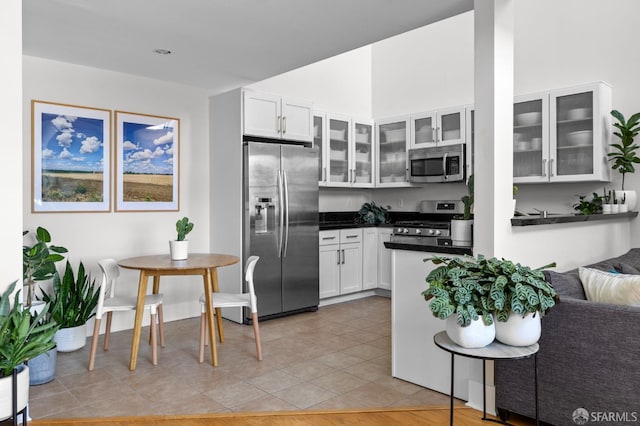 kitchen with white cabinetry, light tile patterned floors, and stainless steel appliances