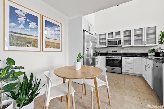 kitchen featuring light tile patterned floors, white cabinetry, sink, and appliances with stainless steel finishes