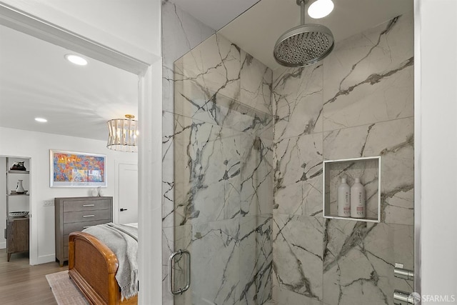 full bath with a marble finish shower, recessed lighting, wood finished floors, and a chandelier