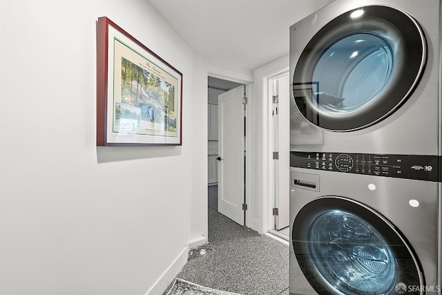 washroom featuring estacked washer and dryer and baseboards