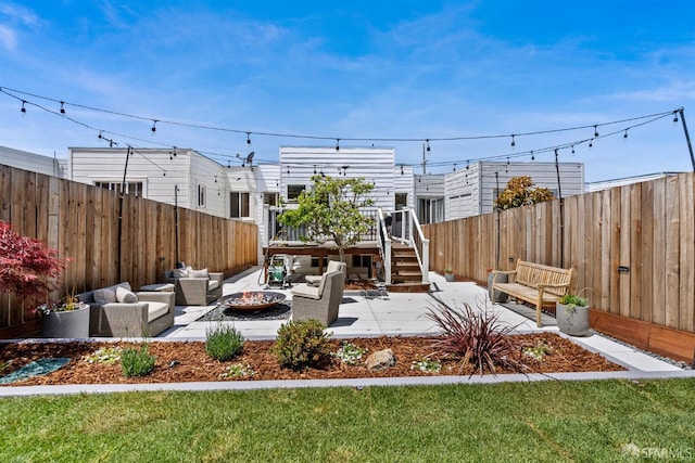 fenced backyard featuring an outdoor living space with a fire pit, a deck, and a patio