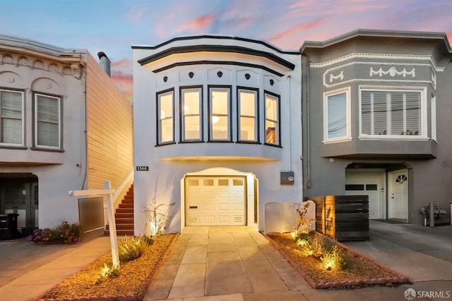 view of front of home featuring stucco siding, an attached garage, and concrete driveway