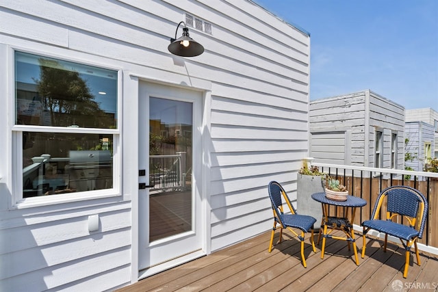 wooden deck featuring a grill