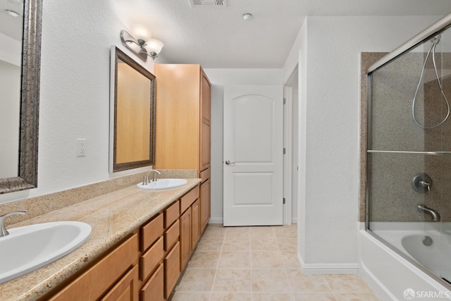 bathroom featuring tile patterned floors, shower / bath combination with glass door, vanity, and a textured ceiling