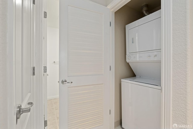 laundry room featuring light tile patterned floors and stacked washer and clothes dryer