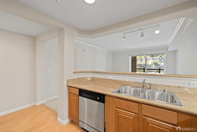 kitchen featuring sink, light hardwood / wood-style flooring, track lighting, ornamental molding, and stainless steel dishwasher