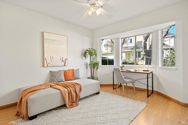 living area with plenty of natural light, wood finished floors, and baseboards