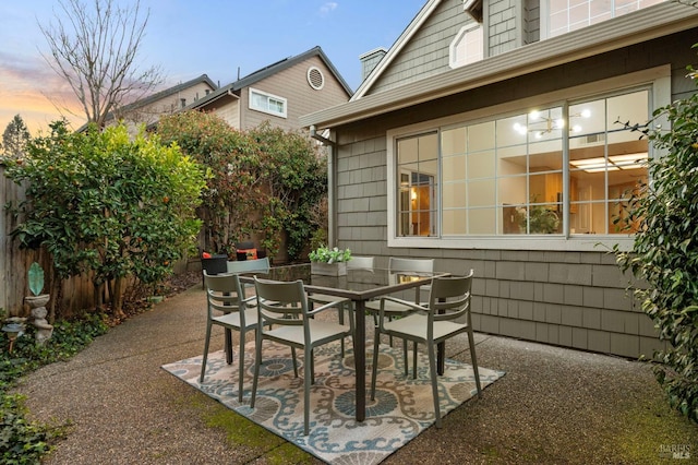 patio terrace at dusk with fence and outdoor dining area