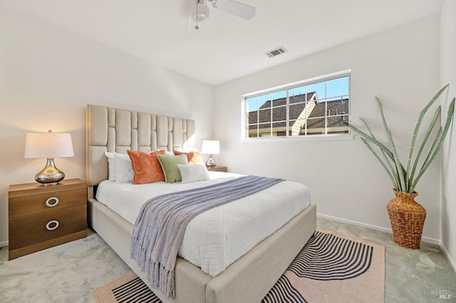 carpeted bedroom featuring a ceiling fan, visible vents, and baseboards