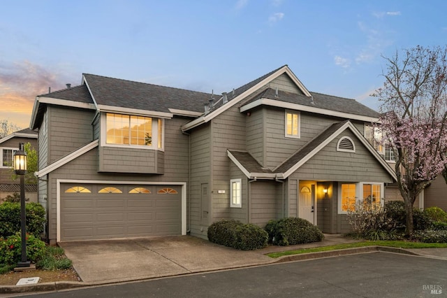 view of front of property featuring a garage, roof with shingles, and driveway