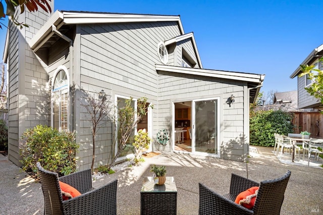 back of house featuring outdoor dining area, a patio area, and fence