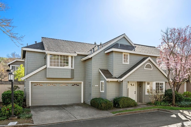 view of front of house with a shingled roof, concrete driveway, and an attached garage