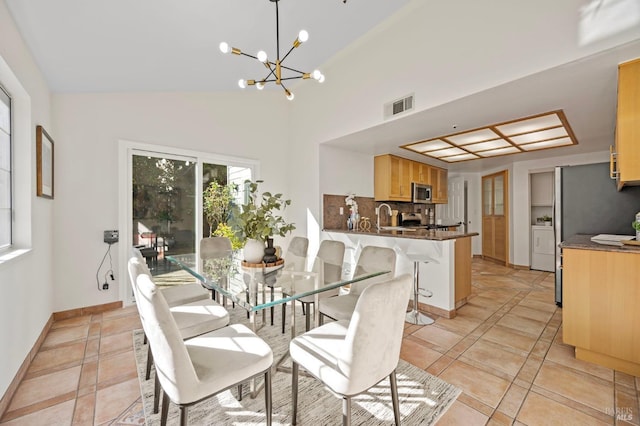 dining area featuring light tile patterned floors, lofted ceiling, visible vents, a chandelier, and baseboards