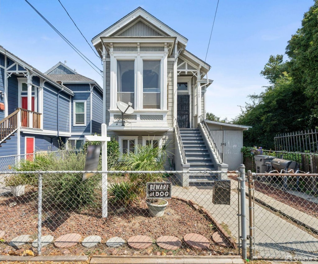 view of front of property featuring a fenced front yard, a gate, and stairway